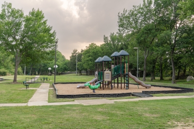 Photo of Sunrise Creek Park play area with trees behind it