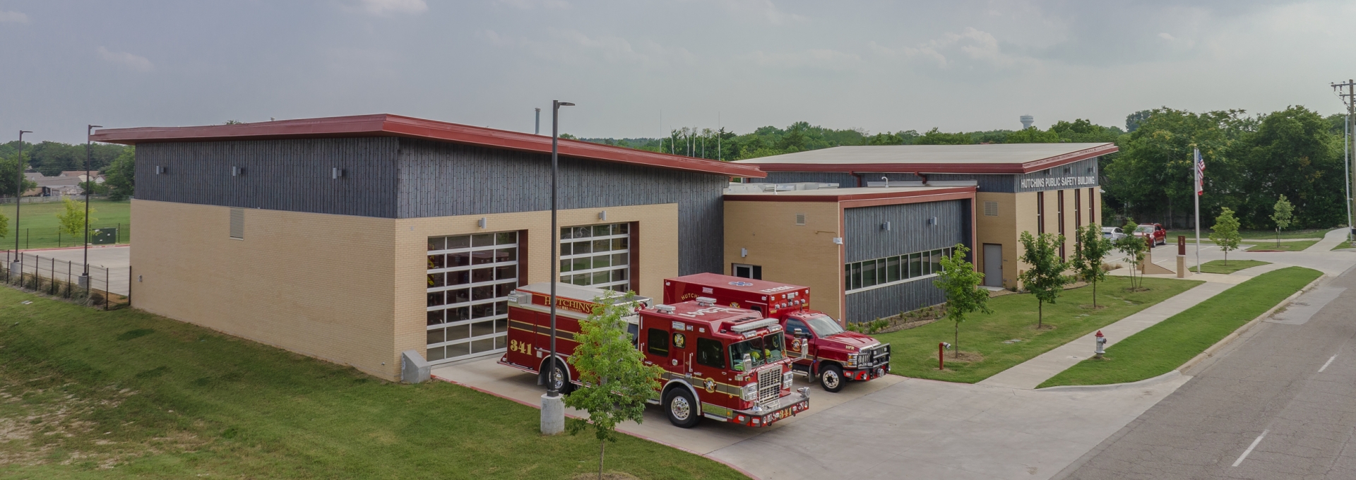 Aerial photo of the public safety building with a fire truck and ambulance parked in front of it. 