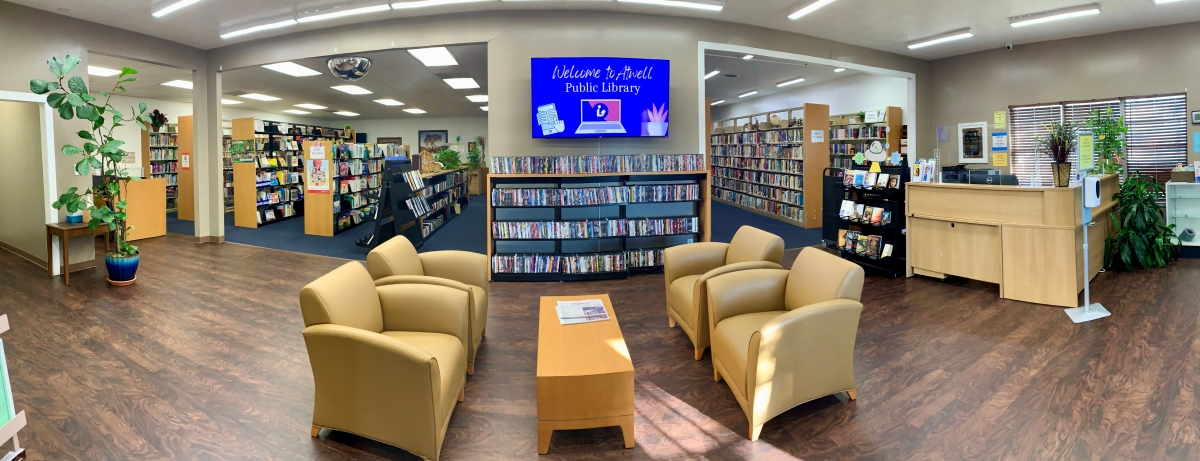 Panorama photo of the inside of the library, showing comfortable chairs and bookshelves