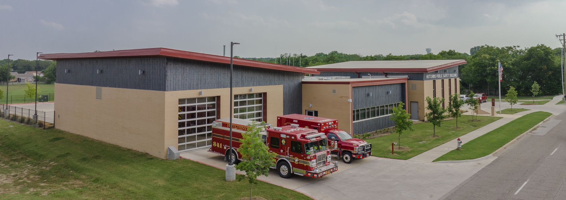Photo of the Public Safety Building with a fire truck and ambulance in front